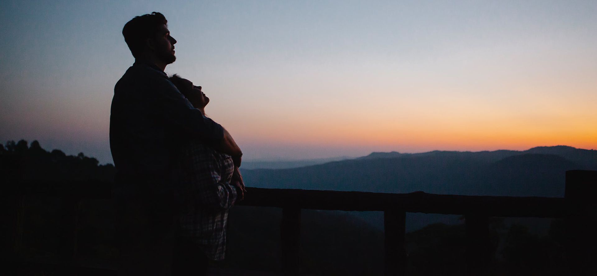 Os jovens vêem fora do pôr-do-sol.